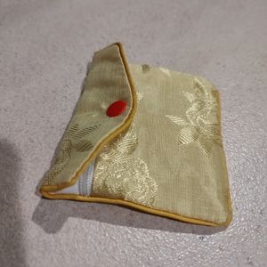 Beautiful gold silk purse features a stunning floral brocade pattern zipper